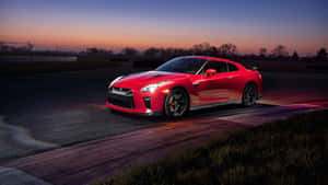 紅色日產GT-R在暮色中的賽道上，天空漸變。 — 日產GTR 壁紙