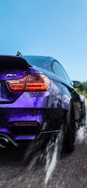 紫色BMW M4在濕滑路面上濺水疾馳 — Galaxy S22 Ultra 壁紙