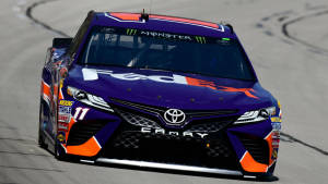 紫色和橙色的NASCAR賽車在賽道上飛馳。 — 海軍藍 壁紙