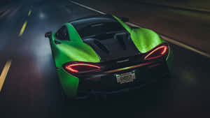 綠色McLaren跑車在夜間潮濕道路上疾馳，尾燈閃爍。 — 賽車 壁紙