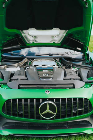 綠色Mercedes-AMG跑車，引擎蓋打開，顯示引擎，停在草地上。 — Mercedes Benz C300 壁紙