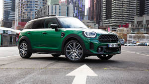 綠色MINI Countryman SUV停放在高樓附近的城市停車場。 — 城市 壁紙