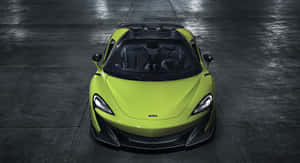 從上方俯瞰一輛萊姆綠色McLaren跑車停在深色潮濕的混凝土地板上。 — 酷炫F1 壁紙