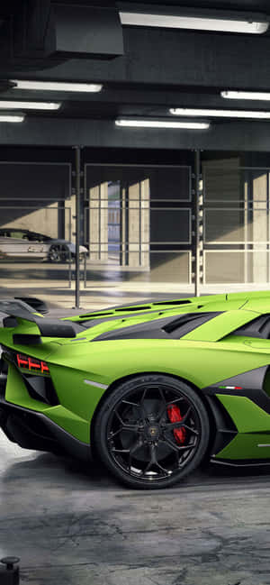 現代工業風車庫中的充滿活力的綠色藍寶堅尼 Aventador SVJ。 — iPhone 15 Pro Max 壁紙