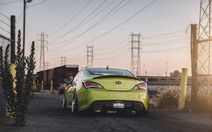 日落時分，萊姆綠色跑車停放在圍欄和火車軌道附近。 — 創世紀 壁紙