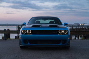 藍色 Dodge Challenger 在黃昏時停在海濱碼頭旁。 — 日落 壁紙