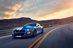 藍色 Shelby Mustang GT500 在日落時分在沙漠高速公路上疾馳。 — 野馬GIF 壁紙