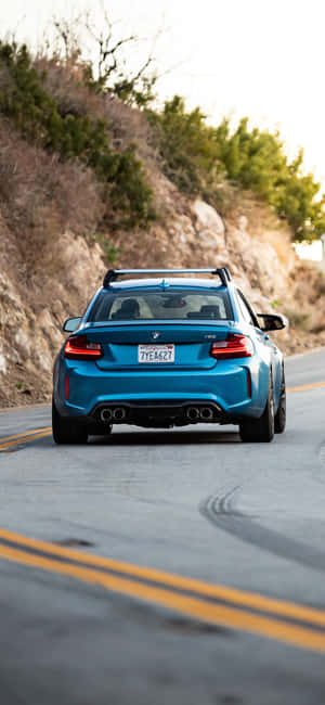藍色BMW M2在山路上行駛留下輪胎痕 — Pixel 7a 壁紙