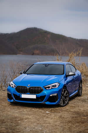 黃昏時分，藍色BMW雙門跑車停泊在湖邊，背景有山丘。 — 小米平板 7 Ultra 壁紙