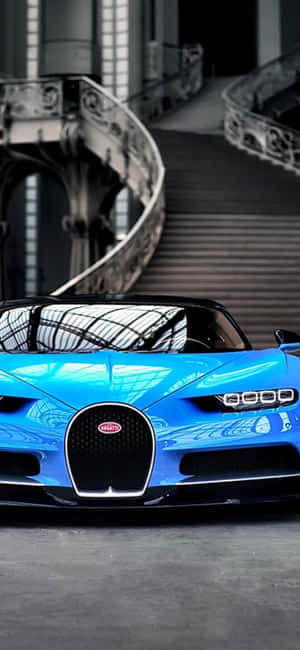 一輛藍色Bugatti跑車停在室內螺旋樓梯附近。 — 紅色美學 iPhone 壁紙