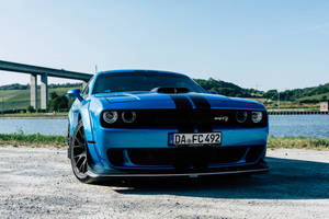 藍色Dodge Challenger SRT停在近水的礫石上，背景有橋樑。 — 道奇挑戰者 壁紙