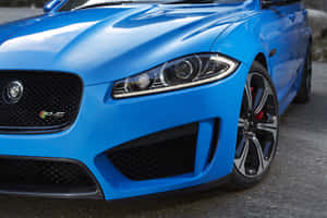 藍色Jaguar F-Type RS跑車前部在瀝青路面上的特寫。 — Surface Pro 壁紙