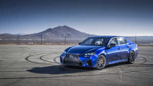 藍色Lexus RC F在賽道上飄移，遠方有山脈。 — Lexus 標誌 壁紙