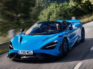 一輛藍色McLaren 720S Spider在山路上疾馳，司機戴著太陽眼鏡。 — 酷炫F1 壁紙