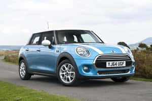 一輛藍色Mini Cooper，白色車頂，停泊在靠近山丘的鄉村道路上。 — 好看汽車 壁紙