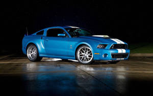藍色Shelby Mustang帶白色條紋，夜間停在星空下潮濕的路面上。 — 福特 壁紙