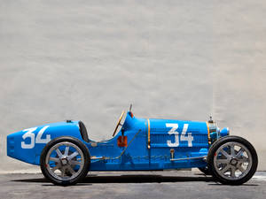 復古藍色賽車34號停靠在混凝土牆邊。 — Bugatti iPhone 壁紙