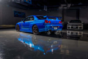 藍色跑車停在拋光車庫中，地板上有倒影。 — 日產 Skyline GTR R34 壁紙