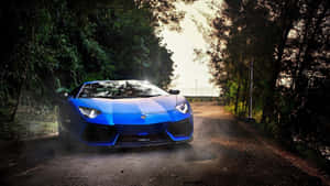 日落時分，藍色藍寶堅尼 Aventador SVJ 停泊在森林道路上。 — 跑車 壁紙