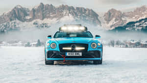 藍色賓利 Bentayga 雪地性能車停放在白雪覆蓋的高山景觀中。 — 7680x4320 壁紙