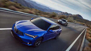日落時分兩輛車在山路上疾馳 — Acura 壁紙