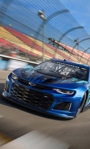 藍色雪佛蘭Camaro ZL1在賽道上飛馳，看台模糊。 — Tecno Megapad 壁紙