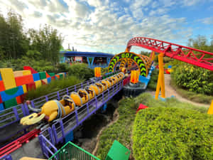 一輛色彩繽紛的雲霄飛車，配備香蕉車廂，蜿蜒穿過樂高公園。 — 4:3 壁紙