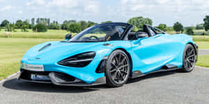 青色McLaren 720S Spider敞篷車停在柏油路上，周圍是綠色的田野和樹木。 — 福特 壁紙