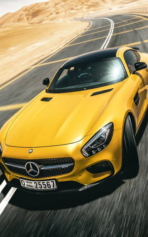黃色 Mercedes 跑車在日落時分的沙漠公路上疾馳。 — Mercedes Benz C300 壁紙