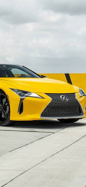 黃色Lexus跑車在混凝土上，天空多雲 — iPhone Air 壁紙
