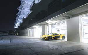 夜間停放在賽車場車庫的黃色McLaren跑車。 — 麥拉倫 壁紙