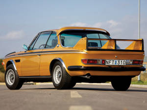 黃色經典BMW 3.0 CSL跑車，後擾流板，瀝青路。 — Mercedes Benz C300 壁紙