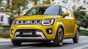 黃色鈴木 Ignis SUV 在城市街道上行駛。 — 鈴木 壁紙