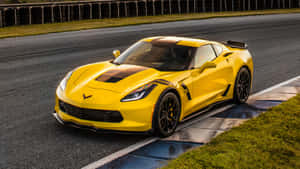 黃色Corvette跑車在潮濕賽道上，帶有草地邊緣。 — 賽車 壁紙