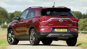 紅色SsangYong Tivoli SUV停泊在碎石路上，靠近樹木。 — 高清汽車 壁紙