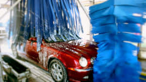 紅色汽車在自動洗車機中被藍色刷子清潔。 — 洗車 壁紙