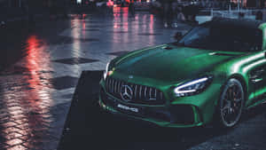 綠色Mercedes-AMG跑車在夜晚停放在濕潤的城市街道上，帶有霓虹反射。 — Mercedes Benz C300 壁紙