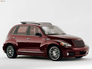 工作室環境中配備鍍鉻輪圈和車頂行李架的栗色PT Cruiser — 飛雅特 壁紙
