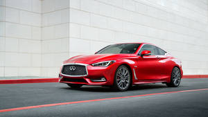 紅色 Infiniti Q60 跑車停在白色牆壁和紅色路緣石旁邊。 — Infiniti 壁紙