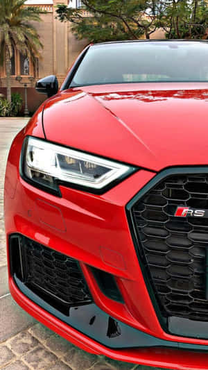 紅色Audi RS汽車停在石頭車道上，後面有棕櫚樹和建築物。 — 奧迪 GIF 壁紙