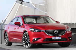 紅色Mazda6轎車停放在現代建築附近的屋頂上。 — 馬自達 壁紙