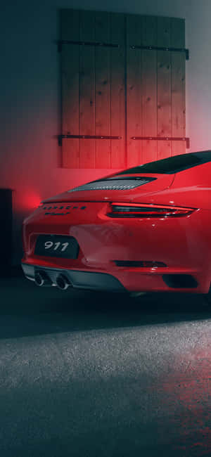 紅色保時捷911跑車在昏暗的車庫中，帶有紅色環境照明。 — Galaxy A56 壁紙