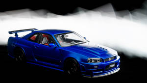 藍色日產Skyline GT-R模型車，配有紅色座椅和黑色車輪，在煙霧繚繞的攝影棚燈光下。