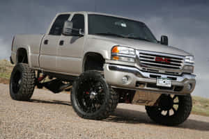 升高的銀色 GMC Sierra 皮卡車，黑色輪圈，礫石路。 — 卡車 壁紙