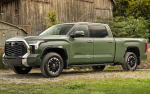 橄欖綠色的豐田Tundra皮卡車停在木製穀倉和草地附近。 — 豐田 壁紙