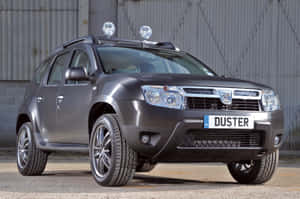灰色Dacia Duster SUV配車頂燈停在金屬牆附近的碎石上。 — 高清汽車 壁紙