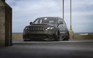 黑色改裝Jeep Grand Cherokee停泊在碼頭上，俯瞰海洋。 — 吉普 壁紙