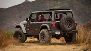 深棕色Jeep Wrangler配備紅色座椅，停放在山區的泥路上。 — 吉普 壁紙