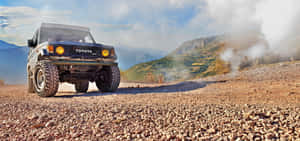 日落時分，藍色豐田 Land Cruiser 在岩石山地行駛。 — 豐田 壁紙
