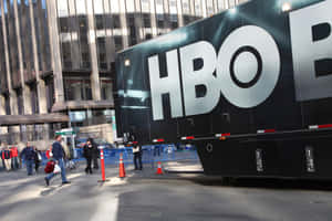 HBO宣傳貨車停放在城市街道上，有行人經過。 — HBO 壁紙